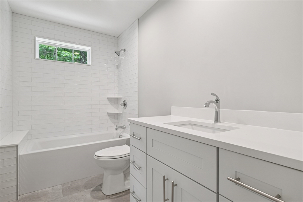 27 James Road, Unit 1 Upton, MA 01568 - Photo 22 of 41 a bathroom with a granite countertop toilet a sink and a bathtub
