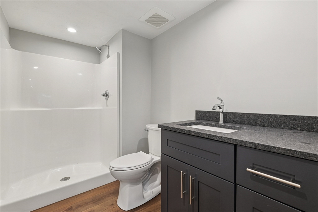 27 James Road, Unit 1 Upton, MA 01568 - Photo 27 of 41 a bathroom with a granite countertop sink a toilet and shower