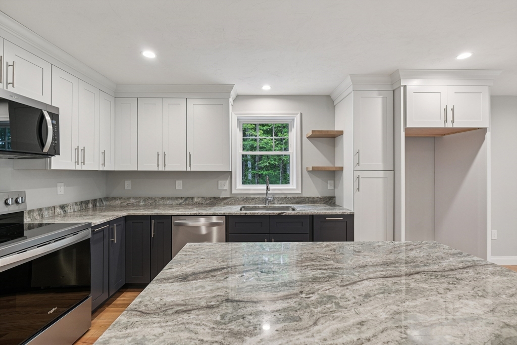 27 James Road, Unit 1 Upton, MA 01568 - Photo 9 of 41 a large kitchen with stainless steel appliances granite countertop a stove a sink and a microwave