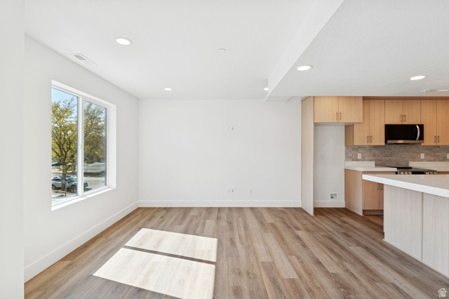 254 North Main Street Bountiful, UT 84010 - Photo 11 of 45 Kitchen featuring light countertops, tasteful backsplash, recessed lighting, light wood-style floors, and stainless steel microwave