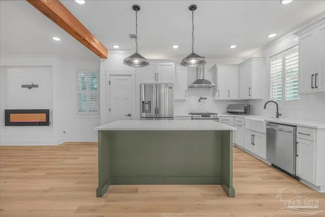 a large kitchen with stainless steel appliances granite countertop a stove a sink and a refrigerator