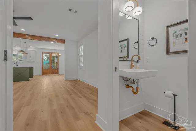 a view of a hallway with wooden floor and a sink