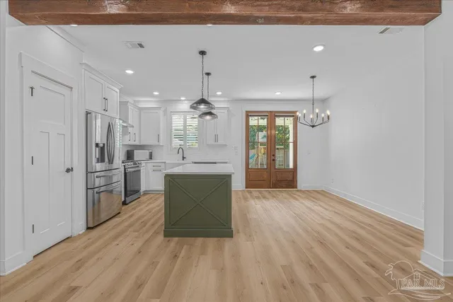 a kitchen with stainless steel appliances kitchen island wooden floors granite counter tops and a window