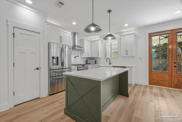 a large kitchen with stainless steel appliances granite countertop a refrigerator a sink and a stove