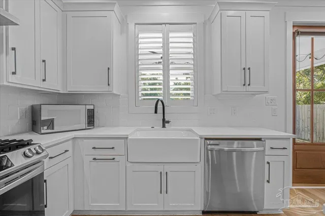 a kitchen with white cabinets and white appliances