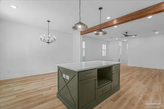 a kitchen with stainless steel appliances granite countertop a stove a sink and a wooden floor