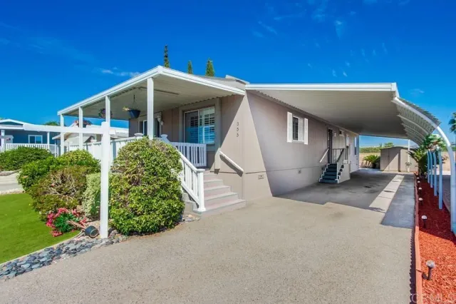 a view of a house with a yard and potted plants