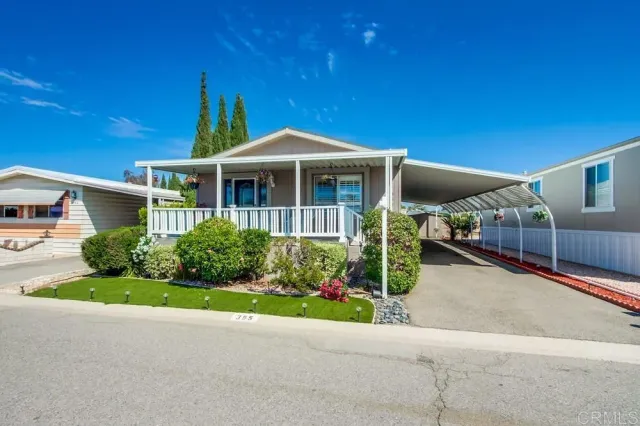 a front view of a house with a yard and potted plants
