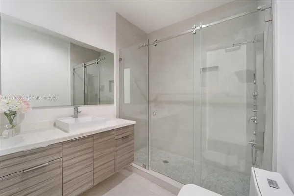 a bathroom with a shower sink vanity and mirror