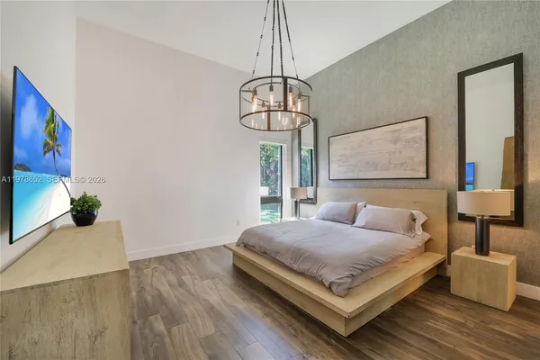 a bedroom with a bed and a chandelier