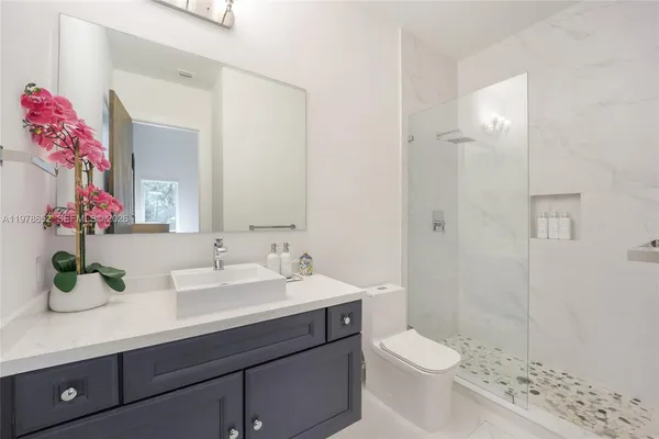 a bathroom with a sink a toilet and shower