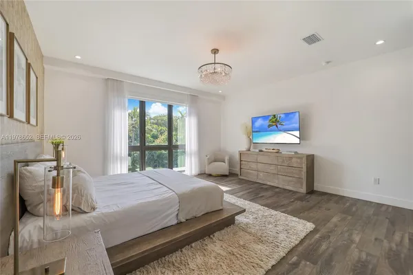 a bedroom with a bed and a flat screen tv