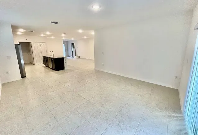 a view of a kitchen with a sink and a refrigerator in it