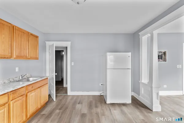 a view of a kitchen with wooden floor and electronic appliances