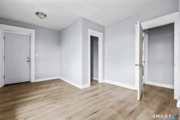 an empty room with wooden floor and closet