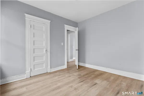 an empty room with wooden floor & closet door