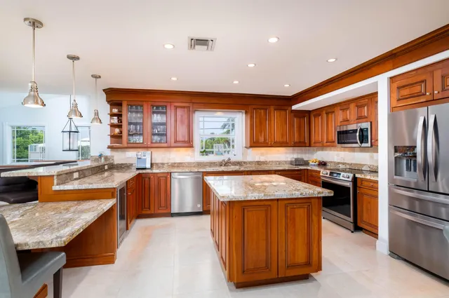 a kitchen with stainless steel appliances granite countertop sink stove top oven and refrigerator