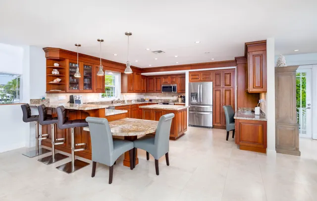 a kitchen with stainless steel appliances granite countertop a refrigerator and a stove top oven