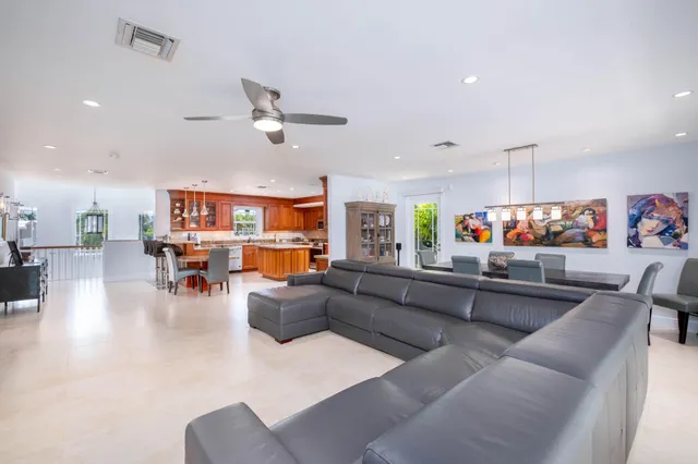 a living room with furniture and a view of kitchen