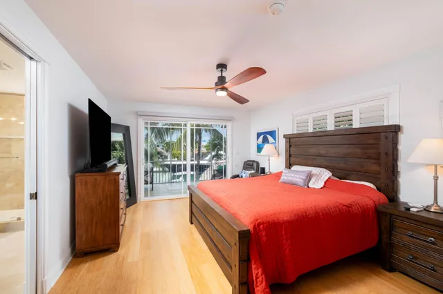 a bedroom with a bed and a flat tv screen on dresser