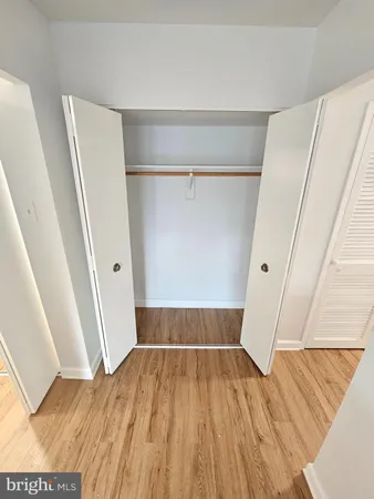 a view of a room with wooden floor and white walls