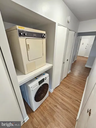 a utility room with wooden floor washer and dryer