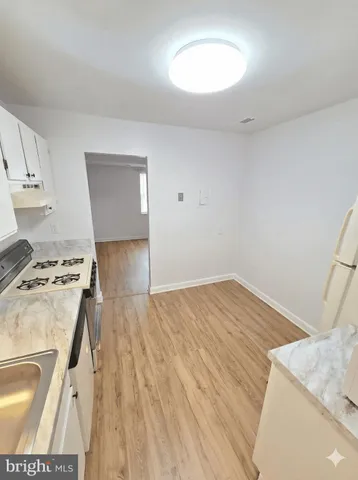a kitchen with a wooden floor and a stove top oven