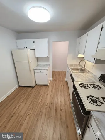 a kitchen with a stove and wooden floor
