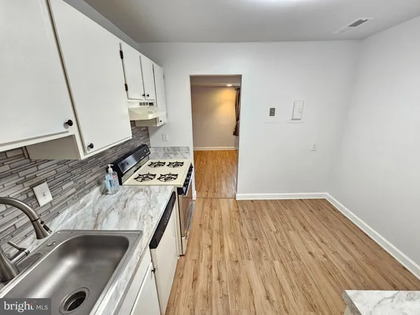 a kitchen with a sink and a stove top oven