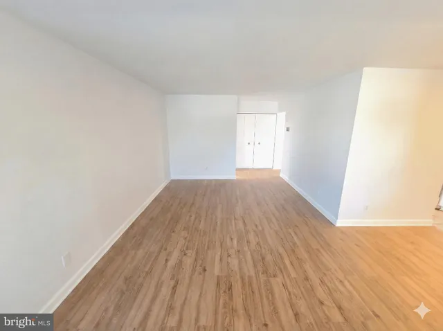 a view of an empty room with wooden floor