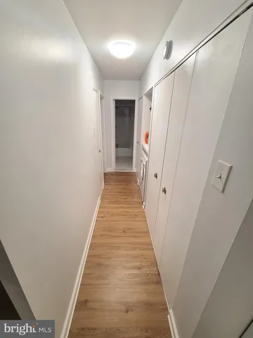 a view of a hallway with wooden floor and staircase