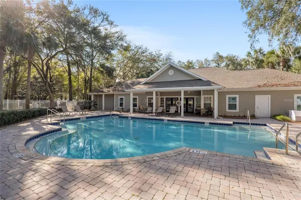 a view of a house with swimming pool and sitting area