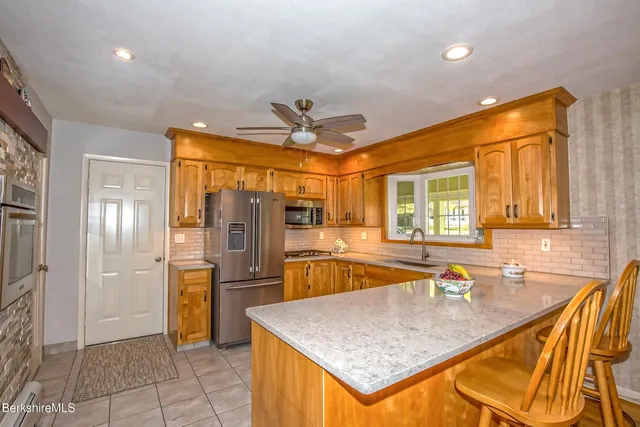 a kitchen with stainless steel appliances granite countertop a sink and a refrigerator