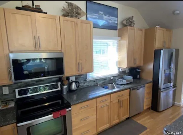 a kitchen with stainless steel appliances a stove a microwave and a refrigerator