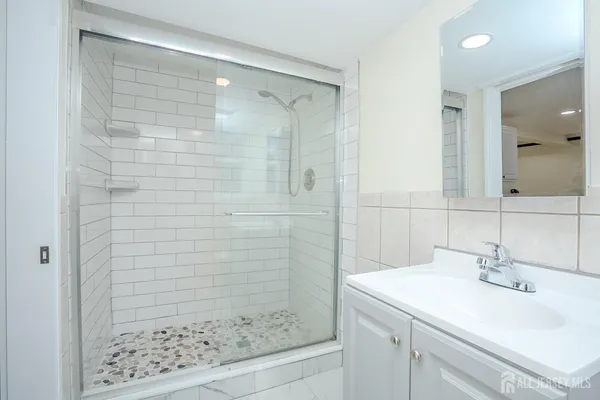a bathroom with a shower sink and mirror