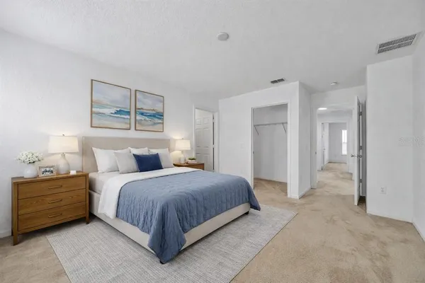 a bedroom with a bed and a painting on the wall