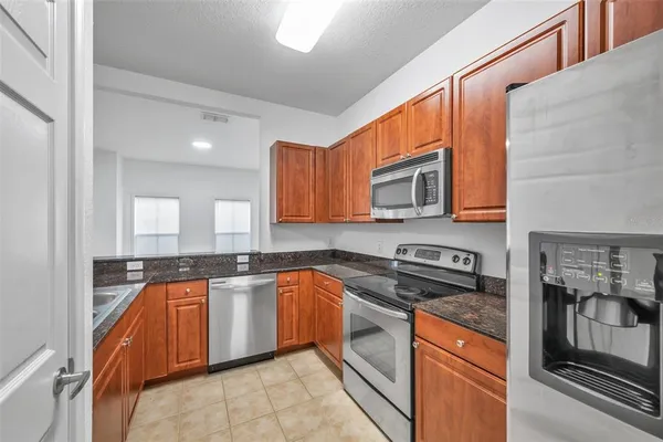 a kitchen with stainless steel appliances granite countertop a sink and cabinets