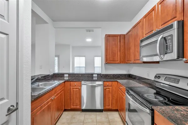 a kitchen with stainless steel appliances granite countertop a stove sink and cabinets