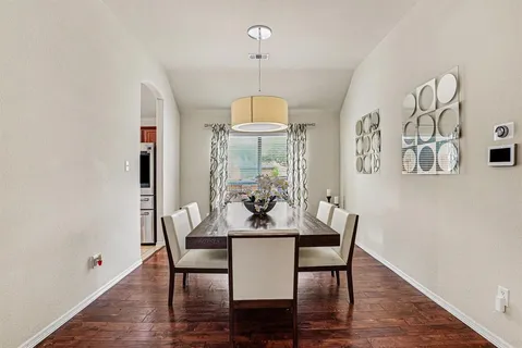 a dining room with furniture a chandelier and wooden floor