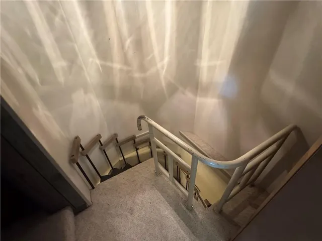 a view of an empty room with wooden floor and furniture