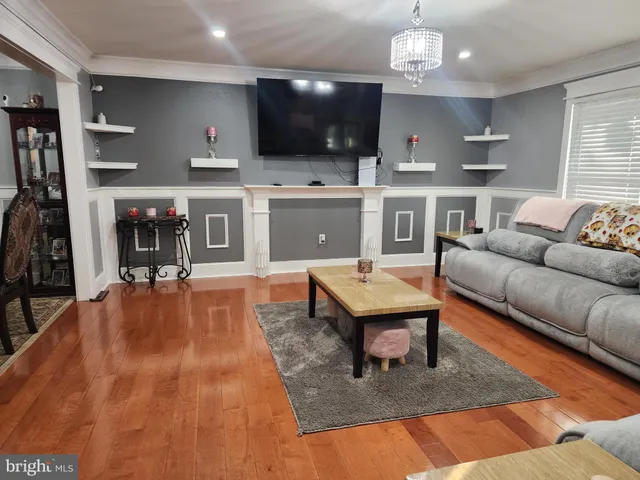 a living room with stainless steel appliances kitchen island granite countertop furniture and a flat screen tv