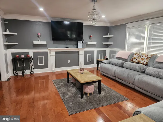 a living room with a couch a dining table chairs and kitchen view