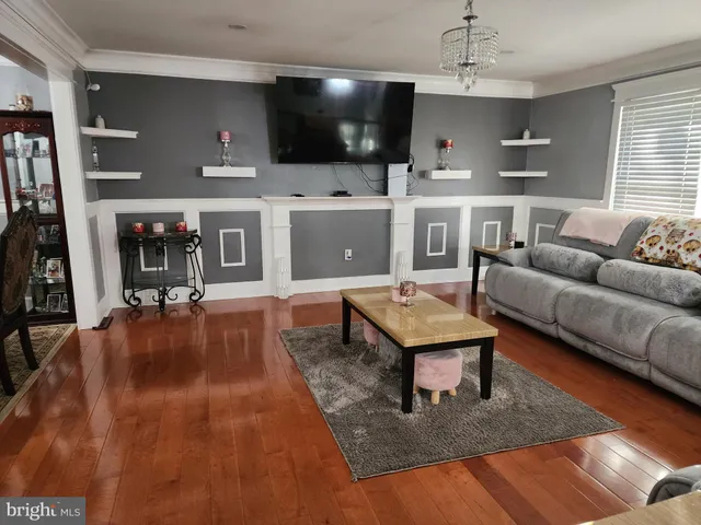 a living room with furniture a flat screen tv and kitchen view
