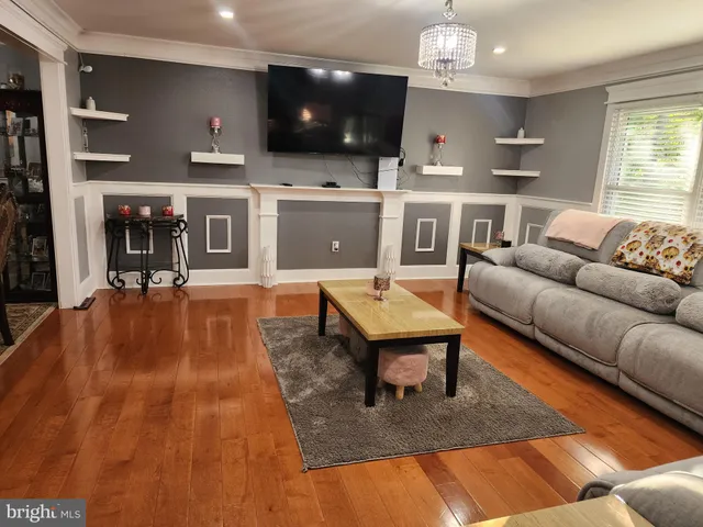 a living room with furniture a flat screen tv and kitchen view