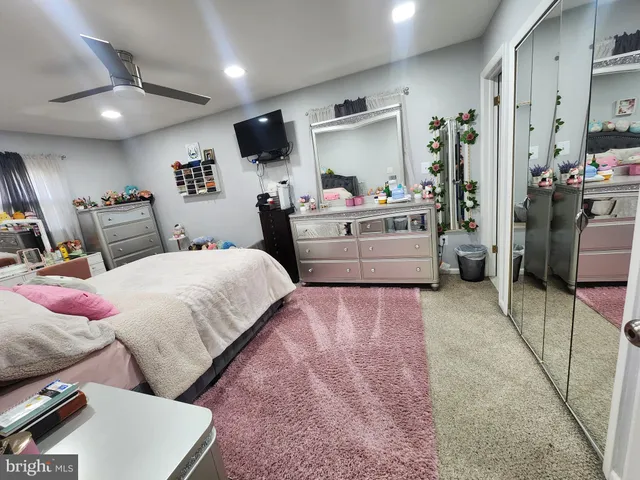 a room with a bed mirror and a window