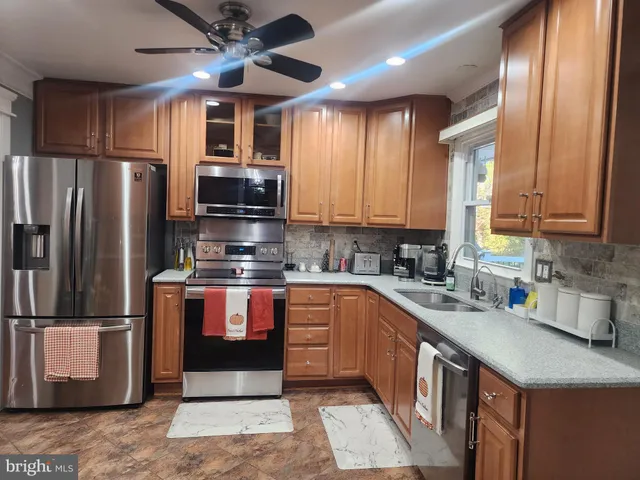 a kitchen with stainless steel appliances granite countertop a refrigerator a stove a sink and a microwave