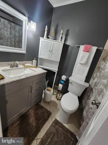 a bathroom with a granite countertop toilet sink and mirror