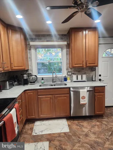 a large kitchen with stainless steel appliances granite countertop a stove a sink dishwasher and a microwave