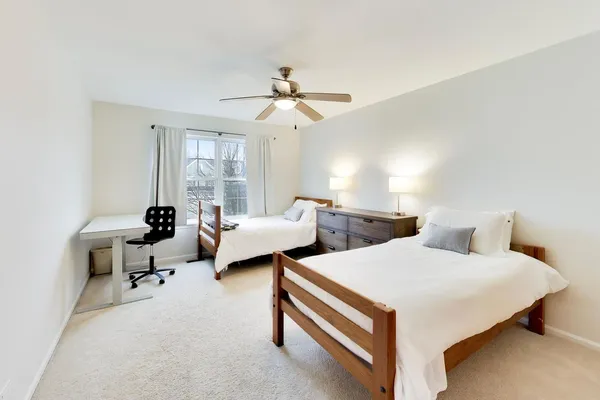 a bedroom with two beds and large windows