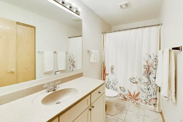a bathroom with a granite countertop sink toilet and shower